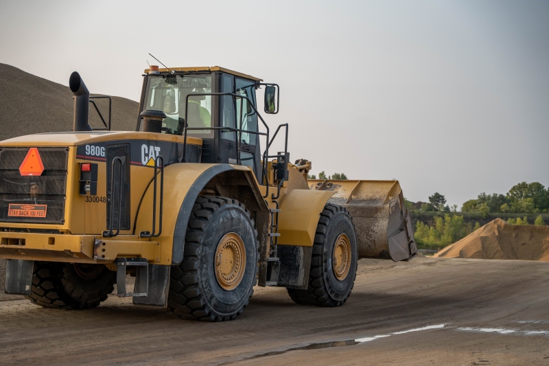 Front-end loader moving dirt during excavation and site preparation on a construction site.
