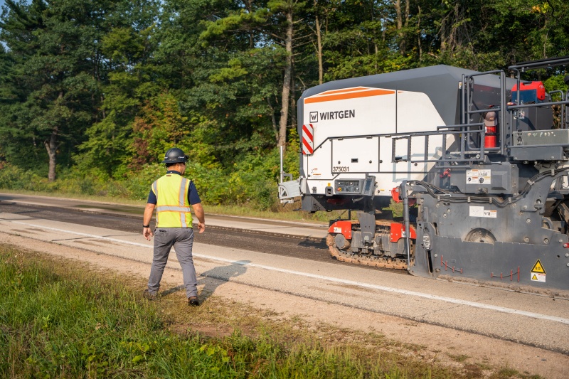 Road construction crew paving an access road as part of sitework for a data center project.
