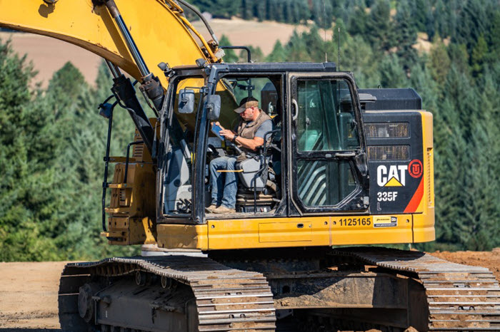 contractor on ipad in dozer